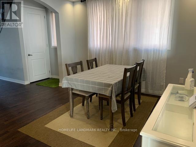 A dining room with a table and chairs.