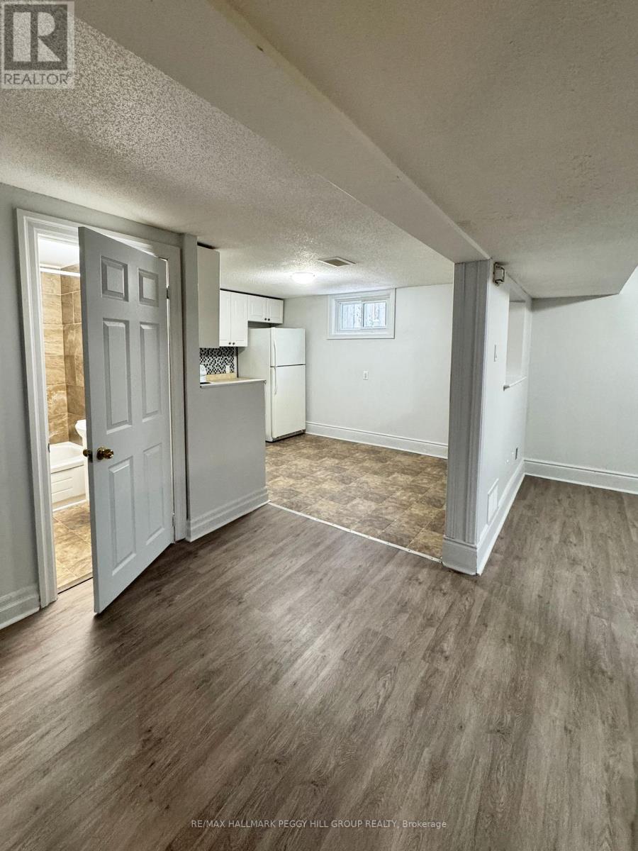 A room with a white door and a grey floor.