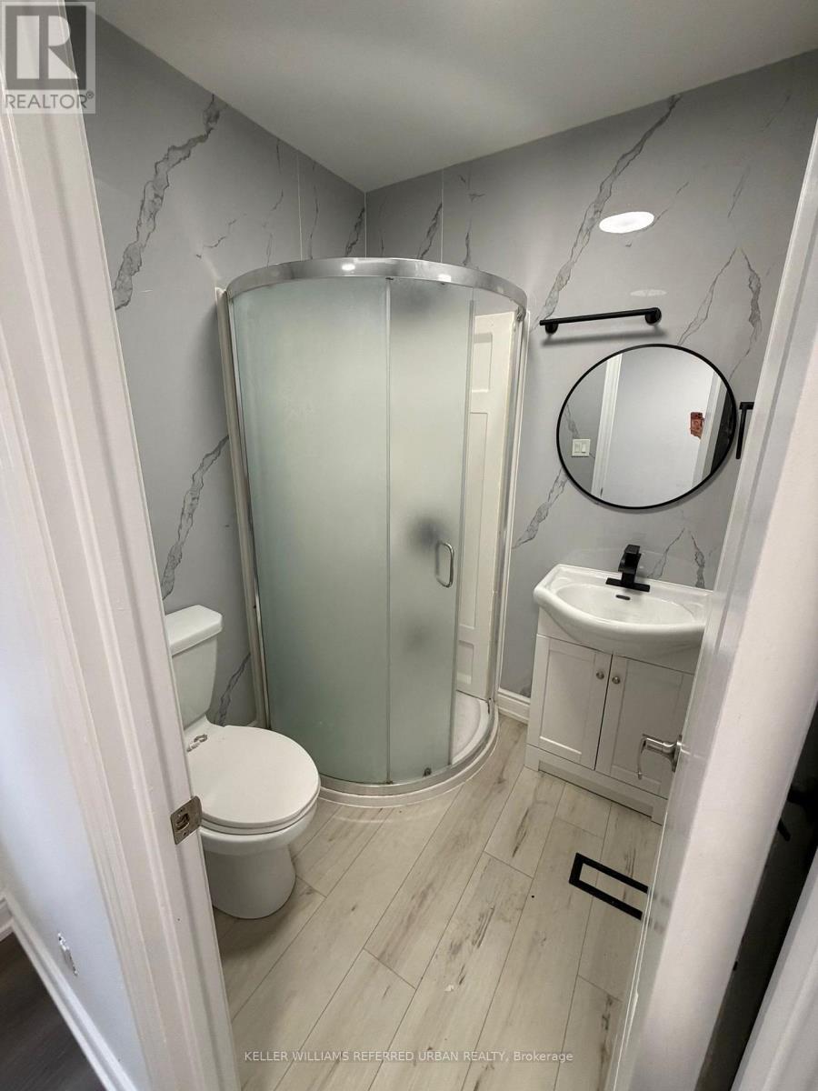 A bathroom with a marble wall and a white toilet.