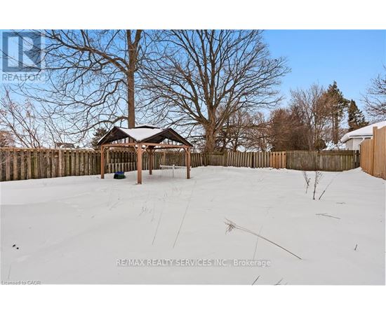 A gazebo sits in the middle of a snow-covered field.