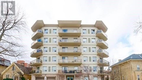 A large, beige apartment building with multiple balconies and windows.