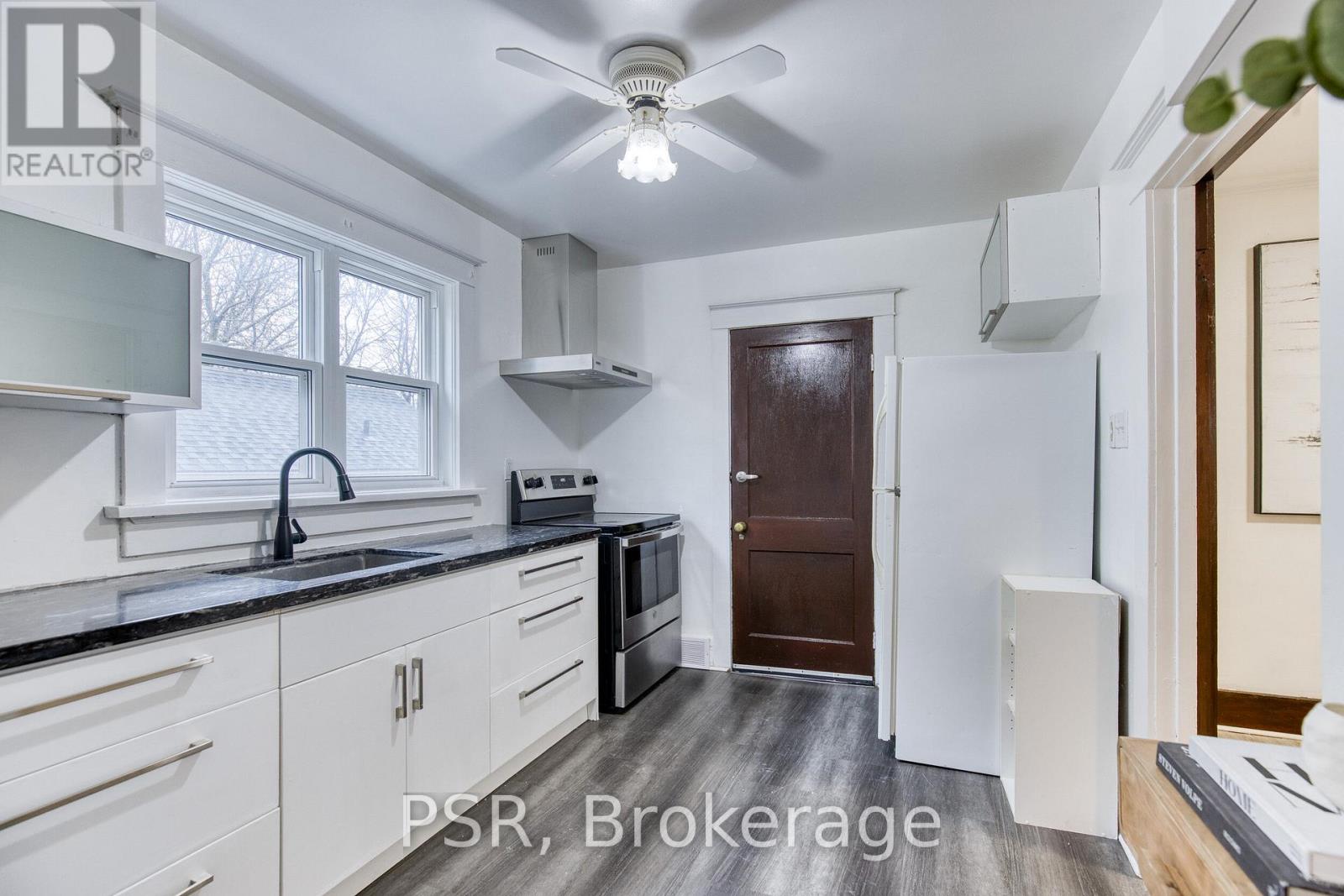 A kitchen with white cabinets and a black countertop.