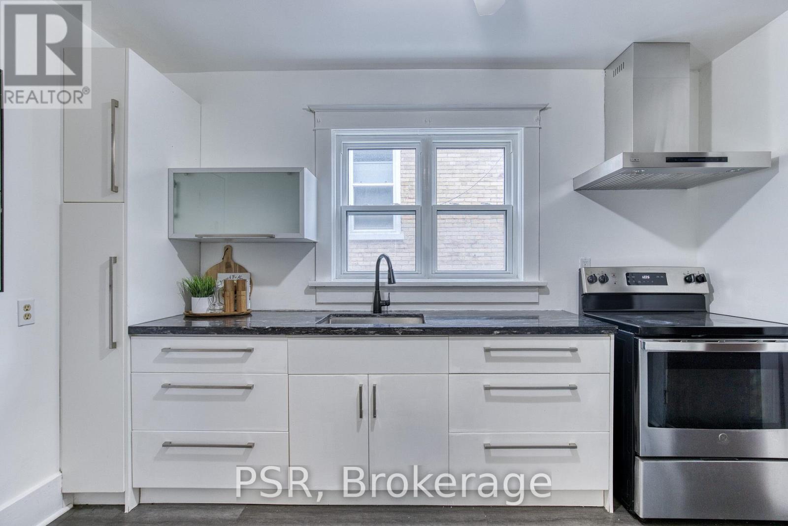 A kitchen with white cabinets and a stainless steel oven.