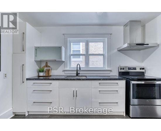 A kitchen with white cabinets and a stainless steel oven.