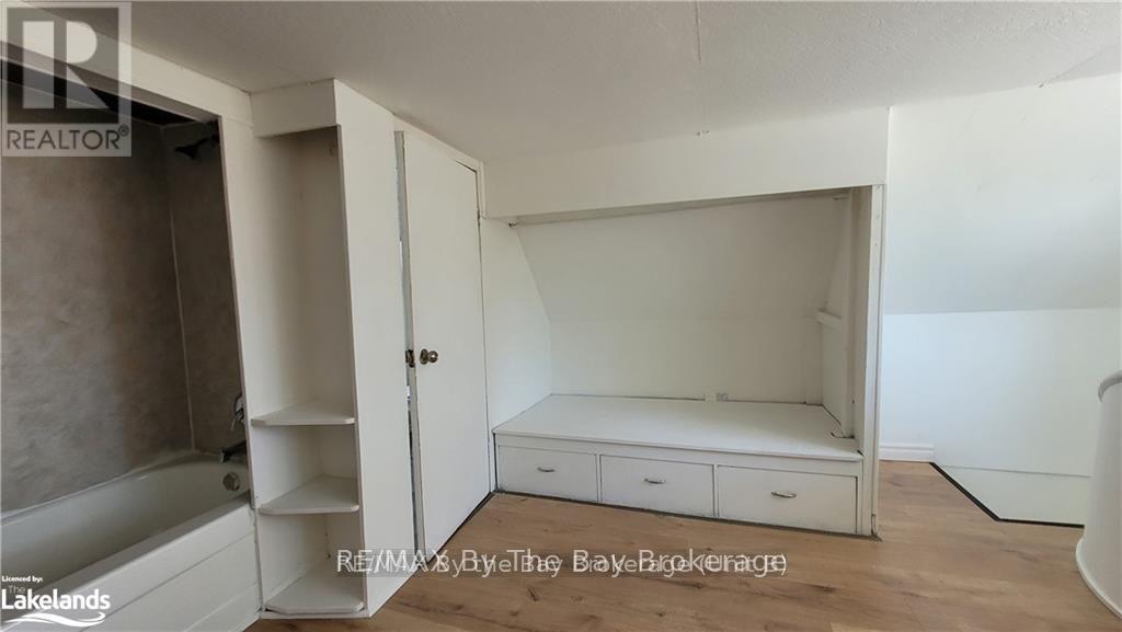A bedroom with a bed, dresser, and open door.