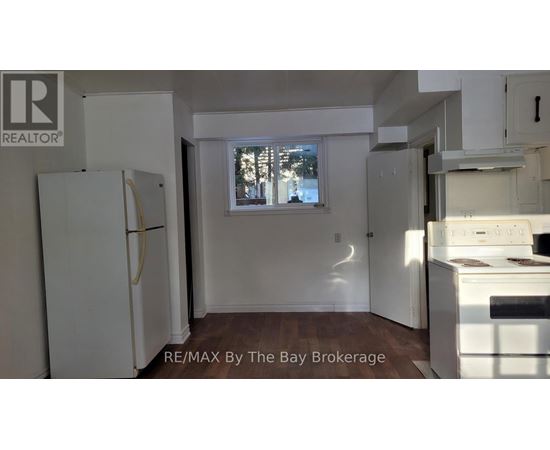 A kitchen with white appliances and a window.
