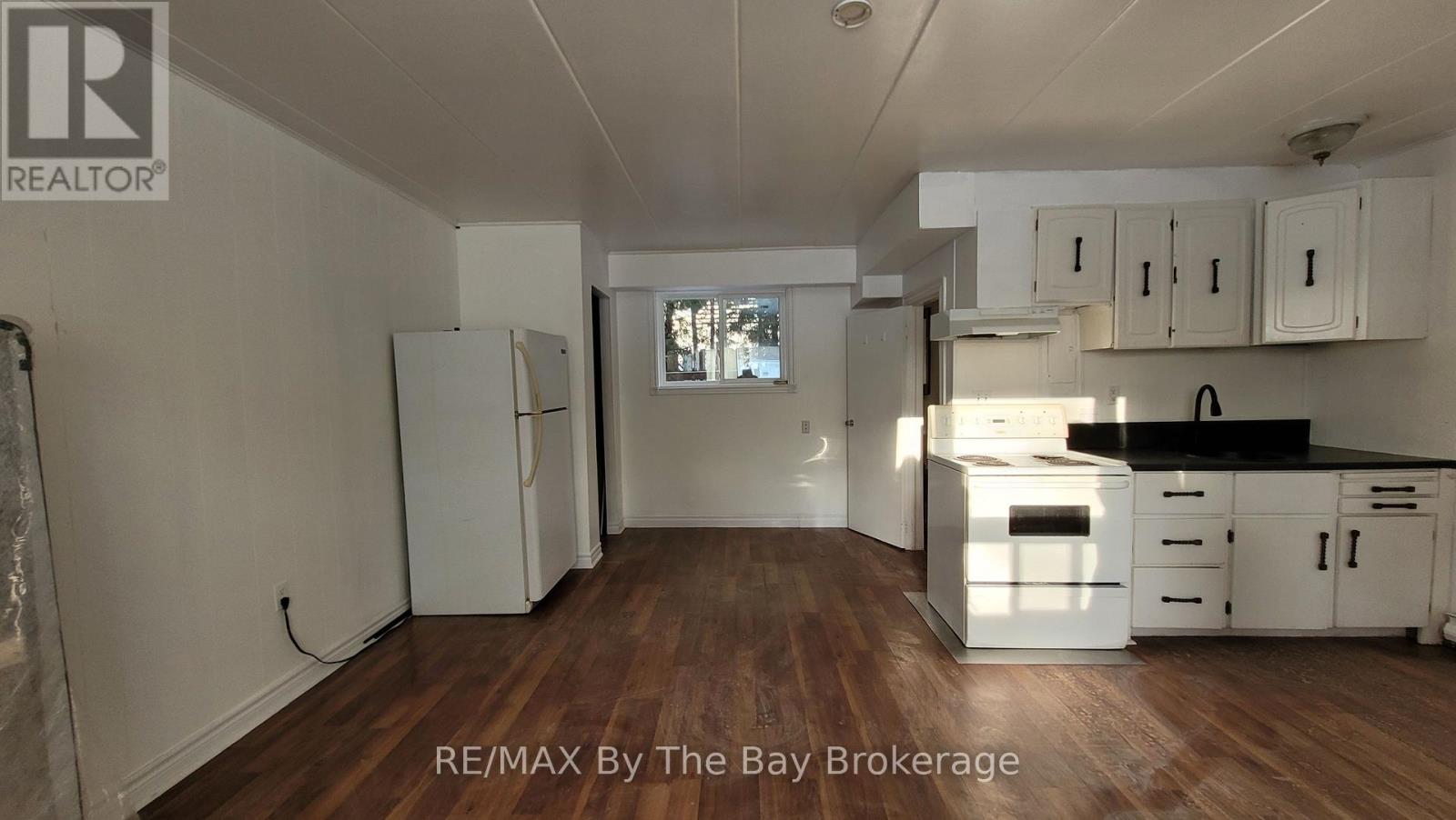 A kitchen with white cabinets and a black countertop.