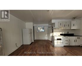 A kitchen with white cabinets and a black countertop.