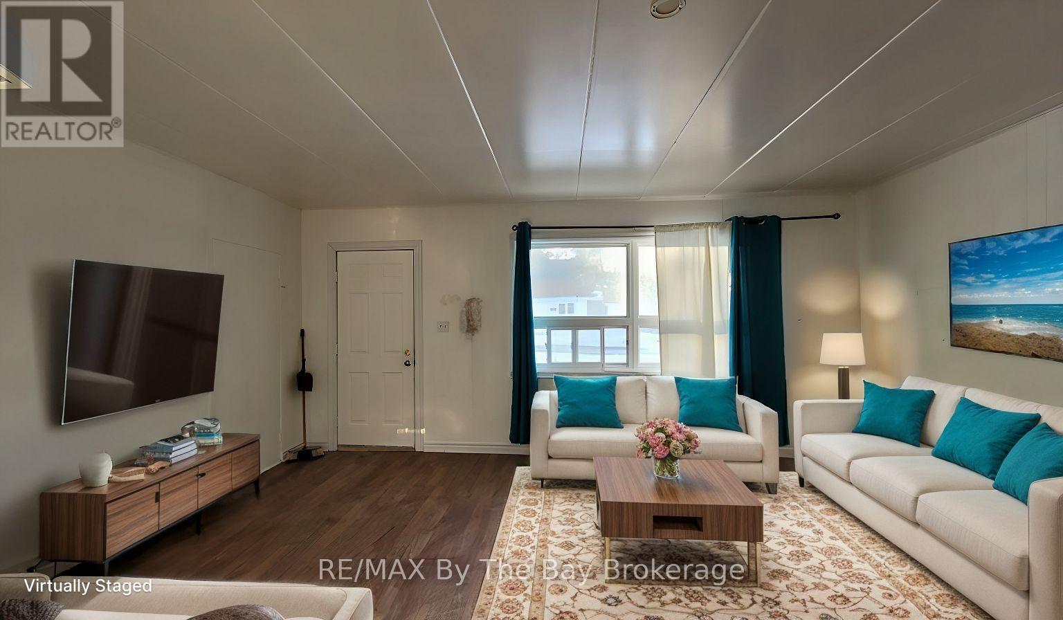 A living room with a white couch, a wooden coffee table, and a painting on the wall.