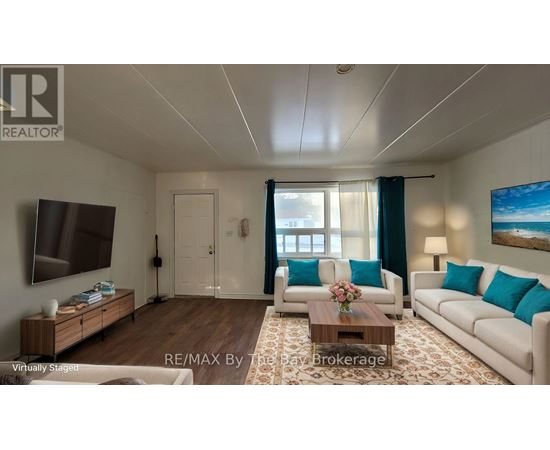 A living room with a white couch, a wooden coffee table, and a painting on the wall.