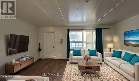 A living room with a white couch, a wooden coffee table, and a painting on the wall.