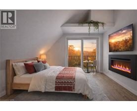 A bedroom with a large bed and a fireplace.