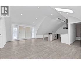 A spacious, well-lit room with a kitchen area and a dining table.