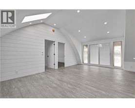 A spacious room with wooden flooring and white walls.