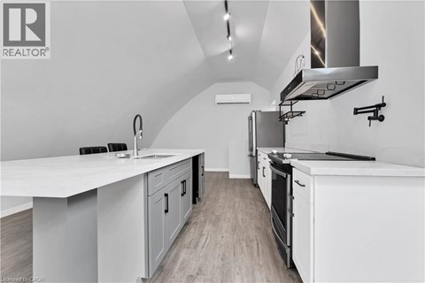 A modern kitchen with white cabinets and a stainless steel range hood.