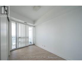 A spacious room with a sliding glass door leading to a balcony.