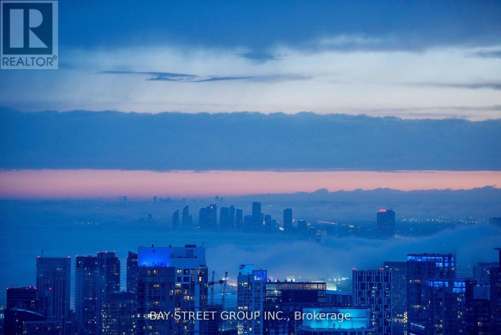A cityscape at dusk with the Bay Street Group Inc. logo superimposed on the buildings.