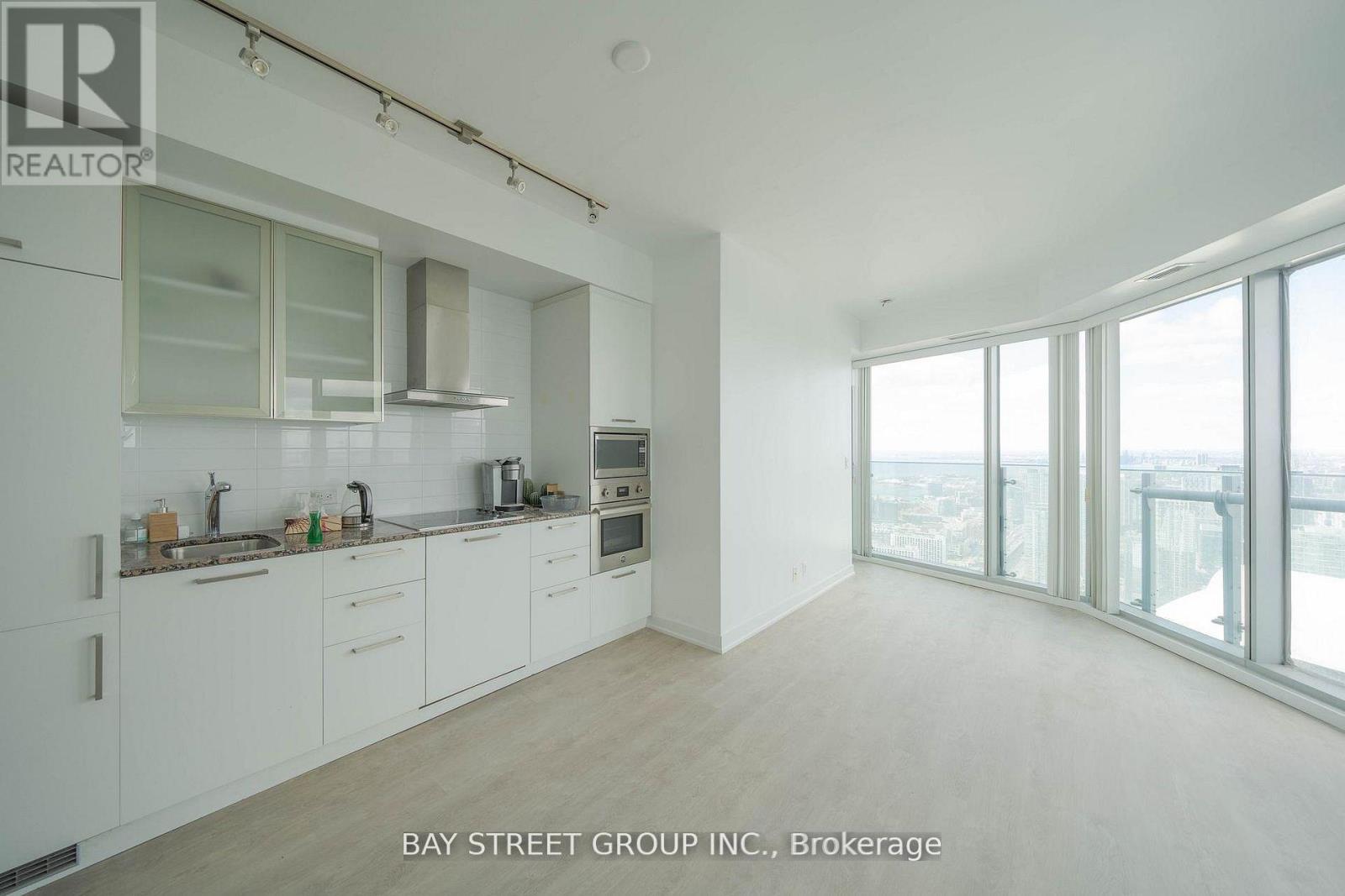 A spacious kitchen with white cabinets and a view of the city.