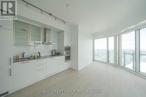 A spacious kitchen with white cabinets and a view of the city.