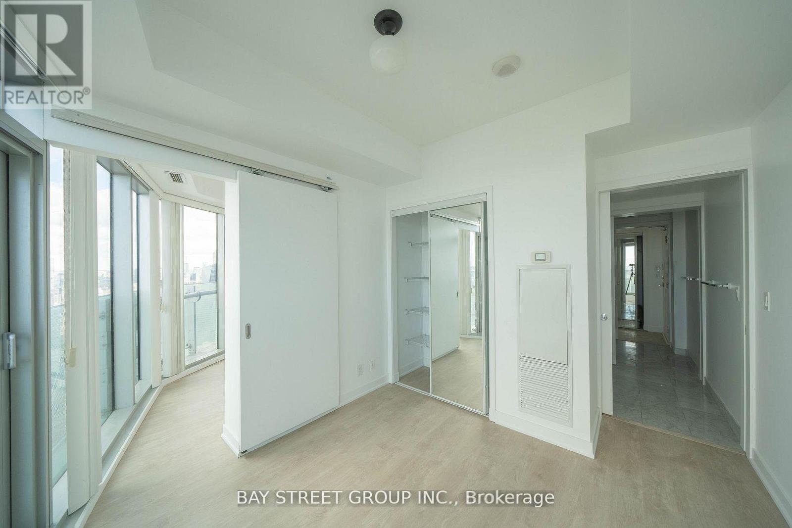 A spacious room with a sliding glass door leading to a balcony.