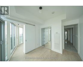 A spacious room with a sliding glass door leading to a balcony.
