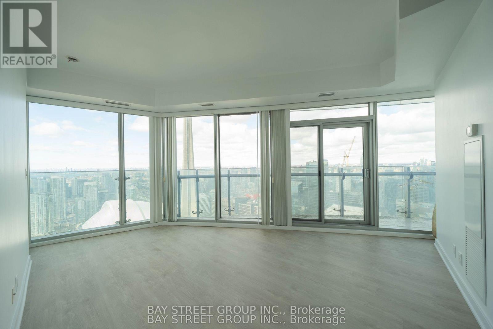 A large empty room with a view of the cityscape outside the windows.