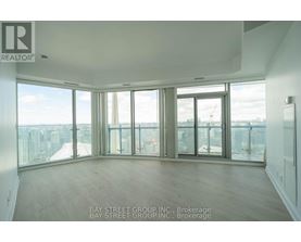 A large empty room with a view of the cityscape outside the windows.