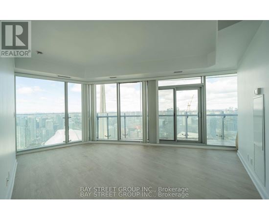 A large empty room with a view of the cityscape outside the windows.