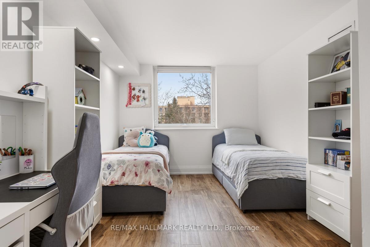 A bedroom with two beds, a desk, and a chair.
