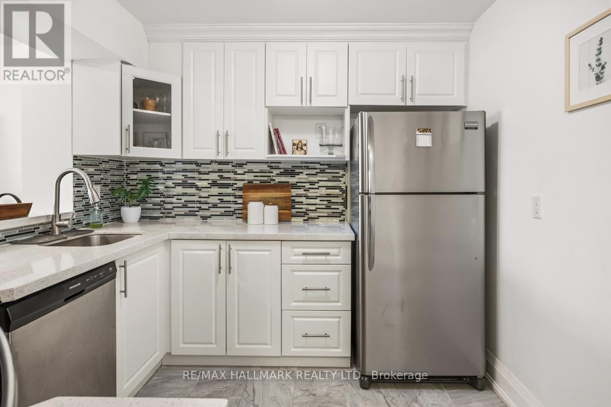A kitchen with white cabinets and a stainless steel refrigerator.