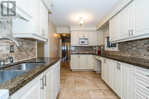 A kitchen with white cabinets and a tiled backsplash.