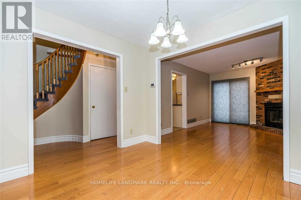 A spacious living room with a staircase and a fireplace.