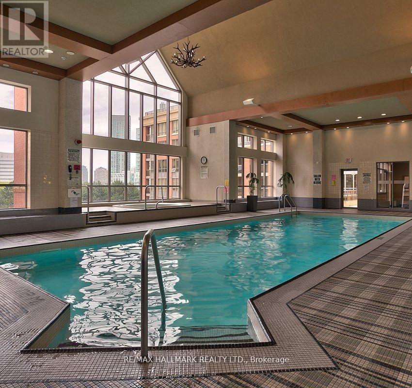 A large indoor swimming pool with a diving board.