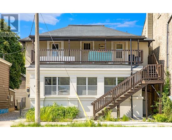 A house with a balcony and stairs leading to the front door.