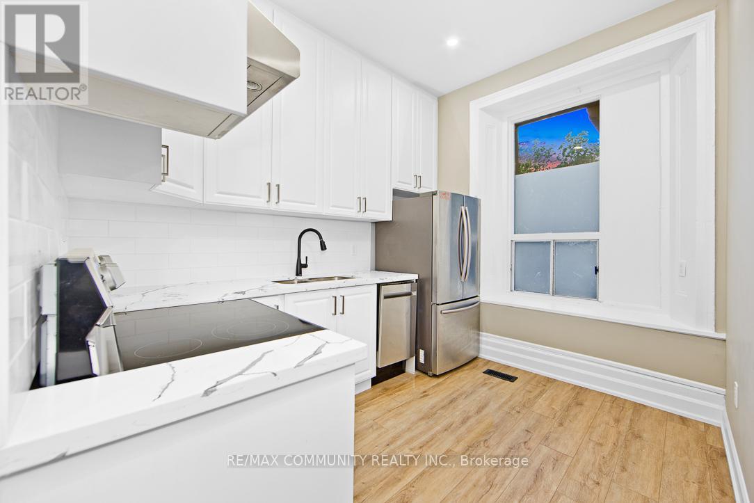 A kitchen with white cabinets and a marble countertop.