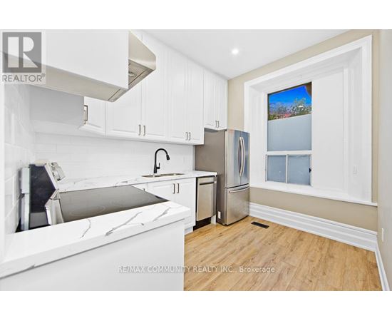 A kitchen with white cabinets and a marble countertop.