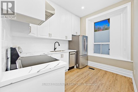 A kitchen with white cabinets and a marble countertop.