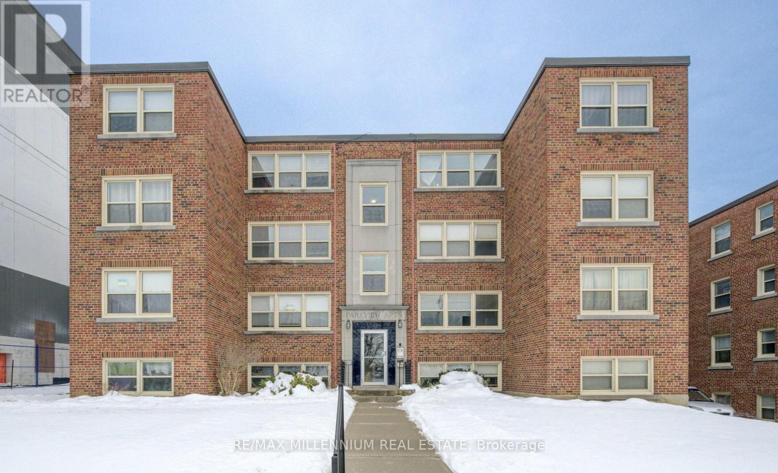 A brick building with a sign in front that says "REALTOR".