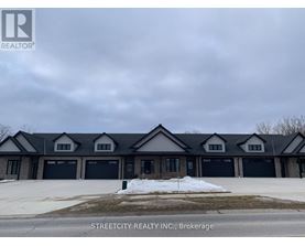 A large, modern building with a dark roof and multiple garage doors is the focus of this image.