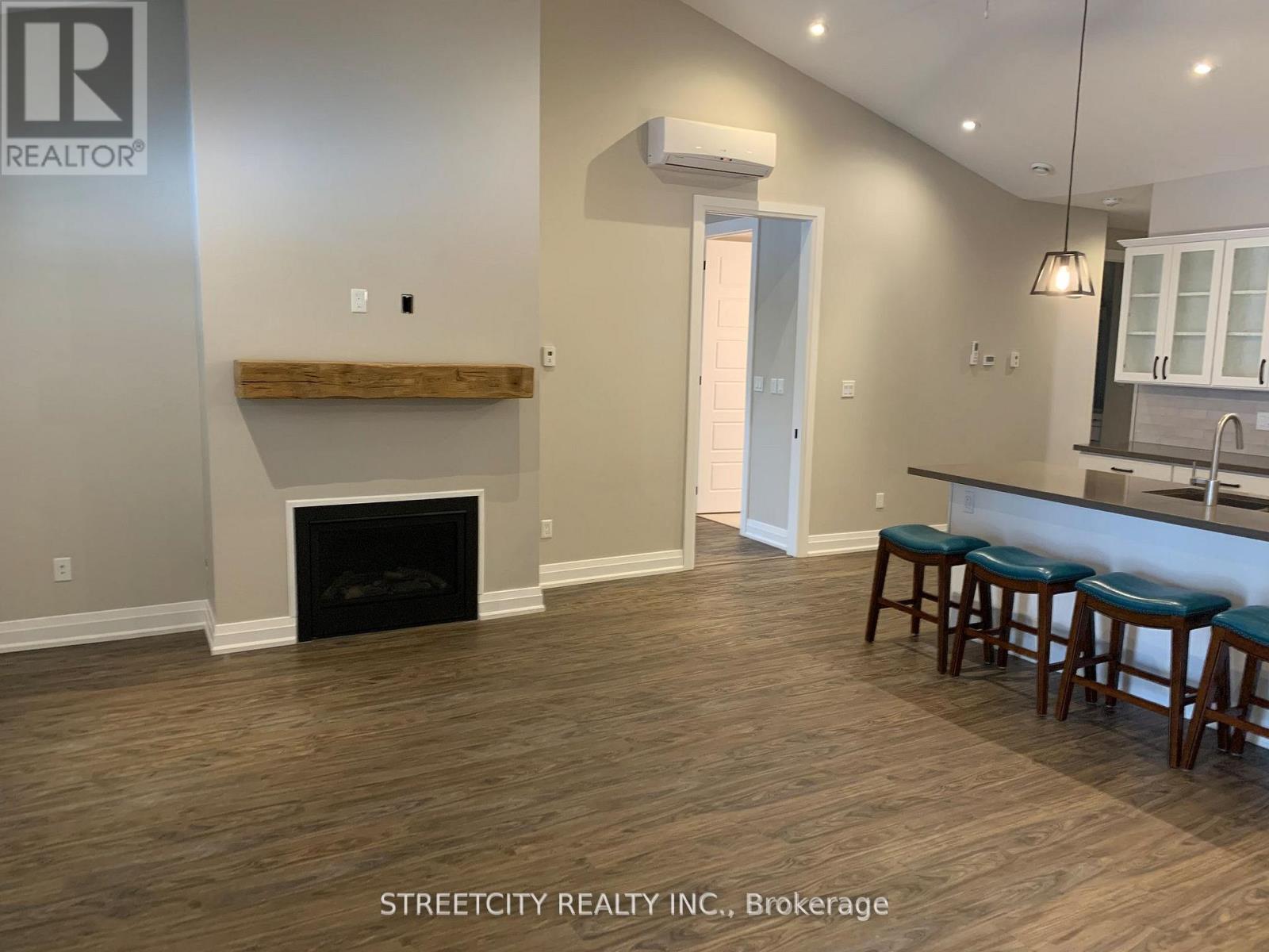 A living room with a fireplace and bar stools.