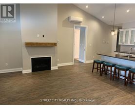 A living room with a fireplace and bar stools.