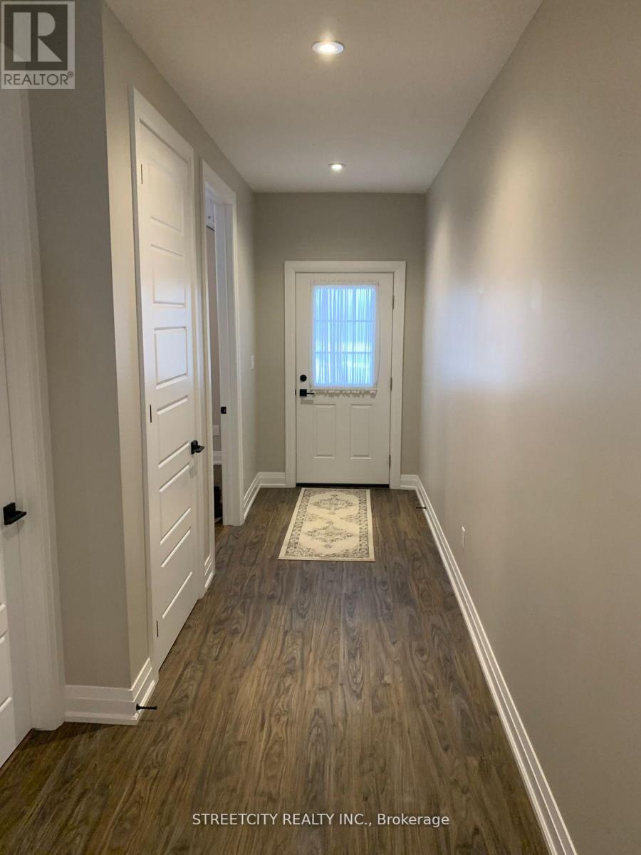 A hallway with wooden floors and white walls.