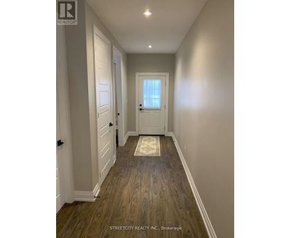 A hallway with wooden floors and white walls.