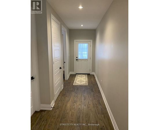 A hallway with wooden floors and white walls.