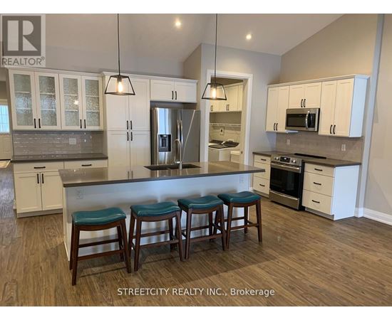 A kitchen with white cabinets and a bar area with stools.