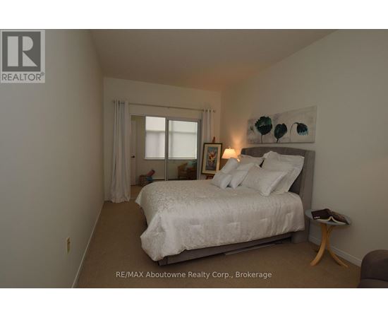 A bedroom with a bed, nightstand, and window.