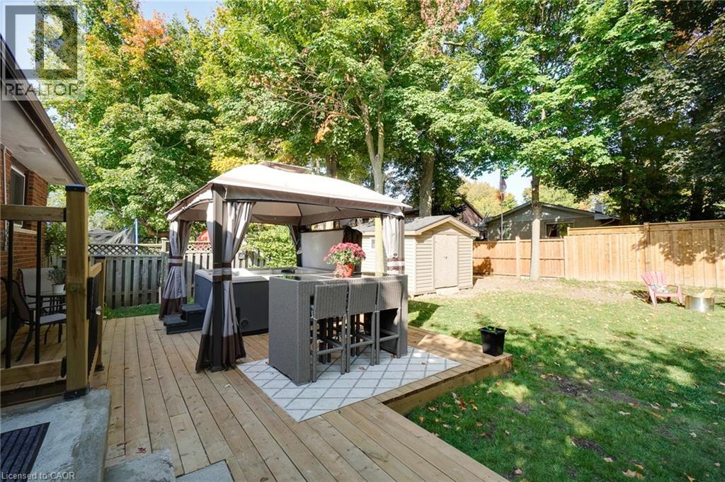 A backyard with a gazebo and a grill.
