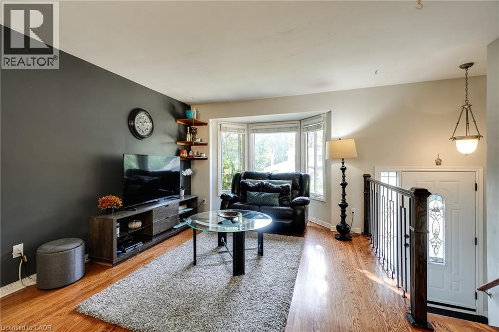 A living room with a black couch and a glass coffee table.