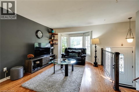 A living room with a black couch and a glass coffee table.