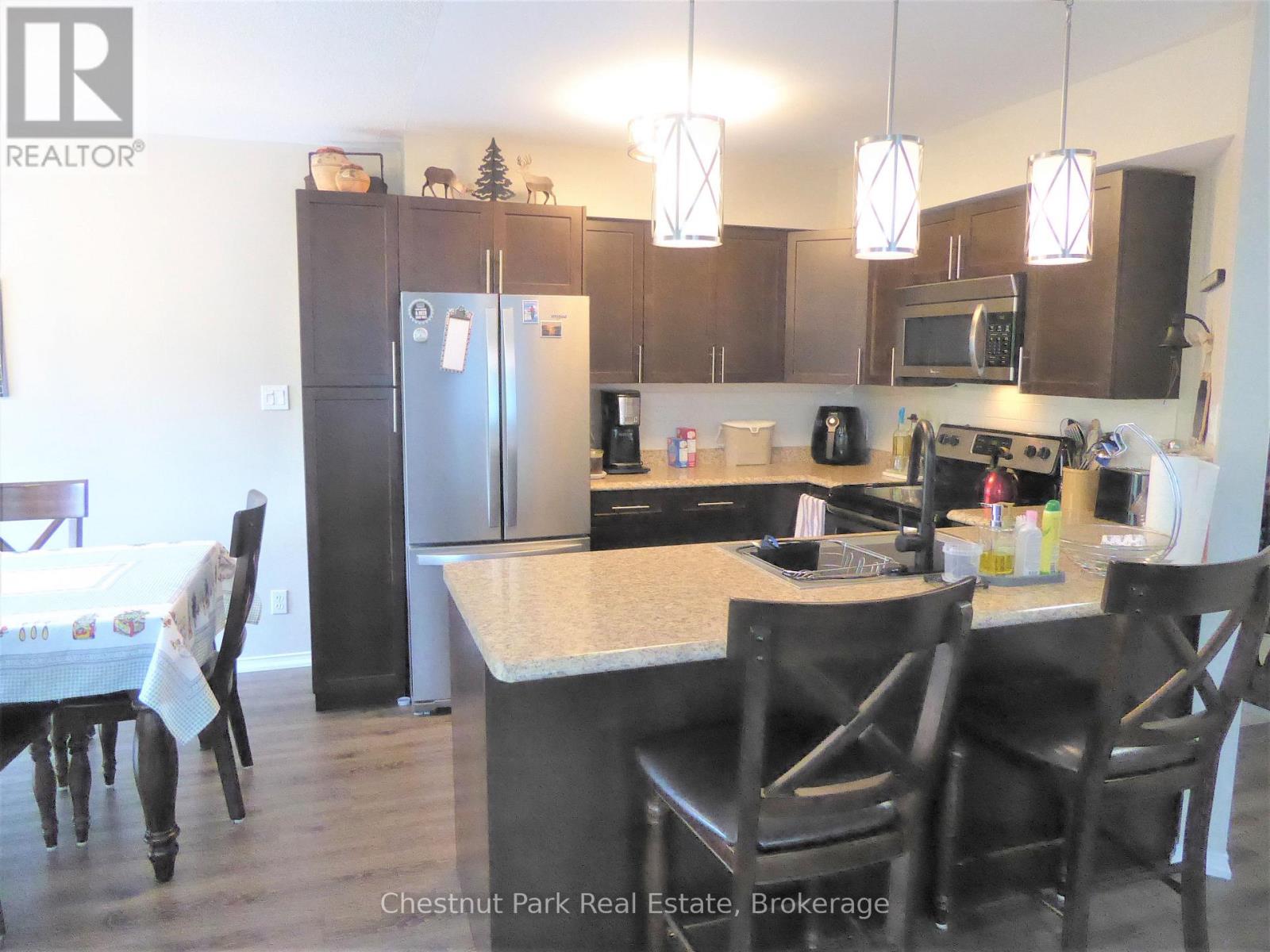 A kitchen with a table and chairs in front of it.